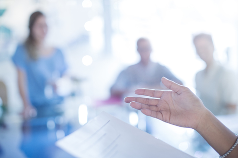 Close up of businesswoman’s hand gesturing to paperwork in meeting stock photo