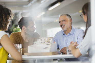 Architects with model meeting in office - HOXF00377