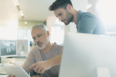 Businessmen with digital tablet talking in office - HOXF00380