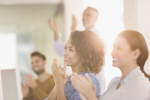 Businesswomen clapping in office stock photo