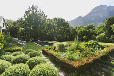 Üppiger sonniger grüner Garten mit Bergblick - HOXF00447