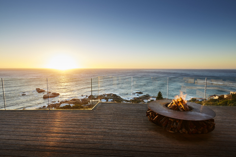 Feuerstelle auf der Luxusterrasse mit Blick auf den Sonnenuntergang, lizenzfreies Stockfoto