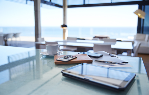 Digital tablet, calculator and coffee on kitchen counter stock photo