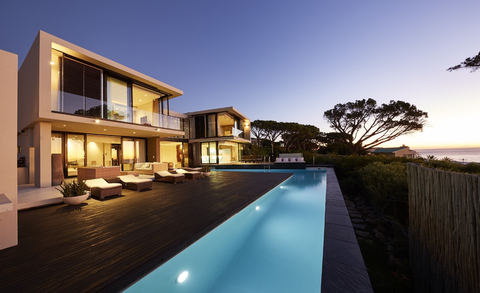 Modern luxury home showcase deck and swimming pool at sunset stock photo