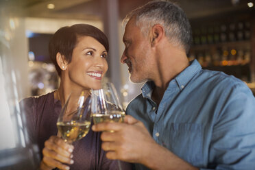 Paar stößt mit Weißweingläsern im Restaurant an - HOXF00510