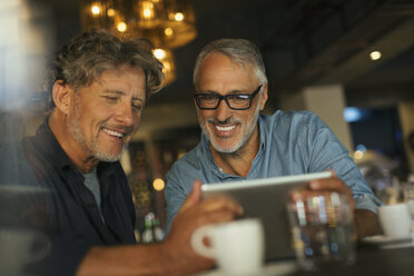 Men using digital tablet at restaurant table - HOXF00514