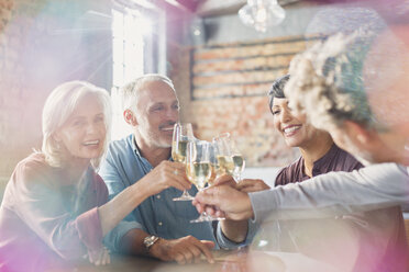 Friends toasting white wine glasses at restaurant table - HOXF00515