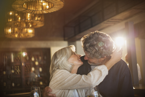 Älteres Paar, das sich in einer Bar umarmt und küsst, lizenzfreies Stockfoto