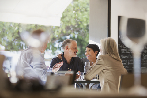 Zärtliches Paar speist mit Freunden am Restauranttisch, lizenzfreies Stockfoto