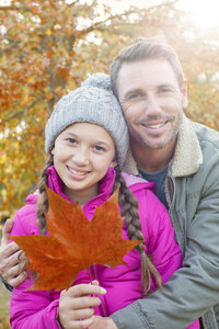 Portrait Vater und Tochter mit Herbstblatt umarmend - HOXF00574