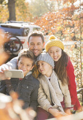 Family taking selfie among autumn leaves - HOXF00584