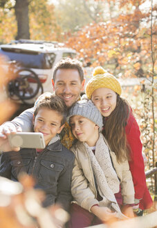 Familie nimmt Selfie unter Herbstblättern - HOXF00584