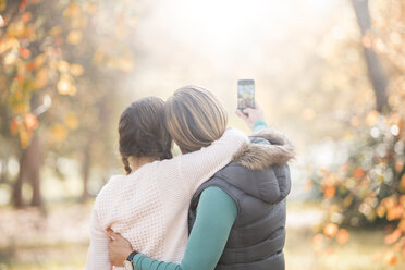 Affectionate mother and daughter taking selfie outdoors - HOXF00595