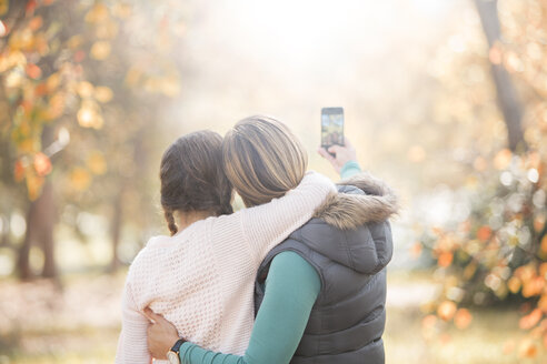 Zärtliche Mutter und Tochter machen ein Selfie im Freien - HOXF00595