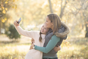 Mother and daughter taking selfie outdoors - HOXF00625