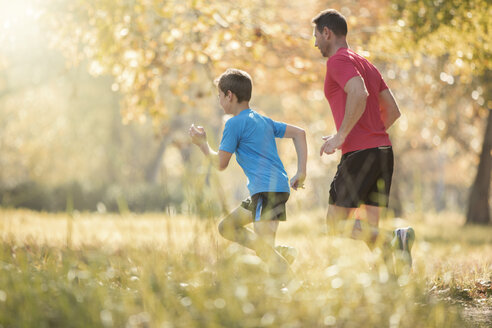 Vater und Sohn joggen im Park - HOXF00635