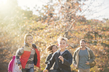 Energetic family running in autumn park - HOXF00648
