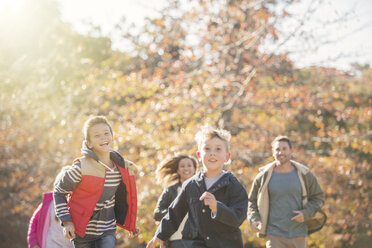 Energiegeladene Familie beim Laufen im Herbstpark - HOXF00648