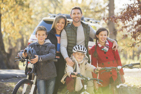 Porträt lächelnde Familie mit Fahrrädern im Freien - HOXF00649