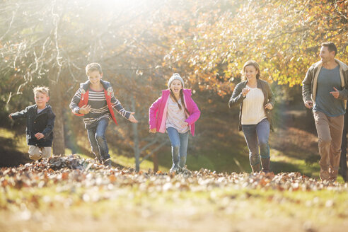 Familie läuft im Park mit Herbstlaub - HOXF00659