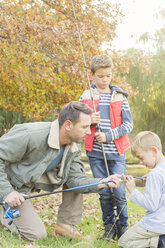 Father teaching sons to prepare fishing rods - HOXF00661