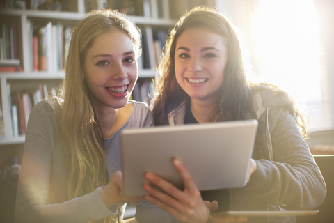 Porträt lächelnde Teenager-Mädchen mit digitalem Tablet, lizenzfreies Stockfoto