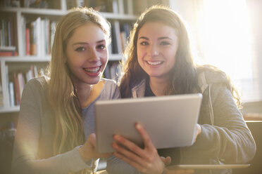 Portrait smiling teenage girls using digital tablet - HOXF00677