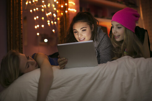 Teenager-Mädchen benutzen digitales Tablet auf dem Bett - HOXF00687