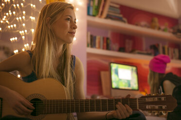 Teenager-Mädchen spielt Gitarre im Schlafzimmer - HOXF00692