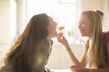 Teenagerin füttert Freundin mit Stäbchen mit Sushi - HOXF00710