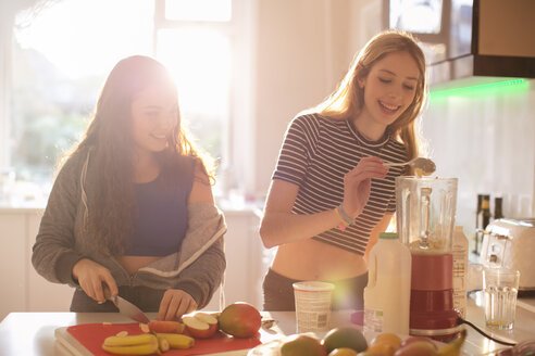 Teenager-Mädchen machen Smoothie in der sonnigen Küche - HOXF00713