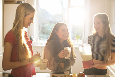 Teenager-Mädchen machen Smoothie in der sonnigen Küche - HOXF00715