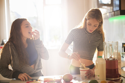Teenager-Mädchen machen Smoothie in der sonnigen Küche - HOXF00726