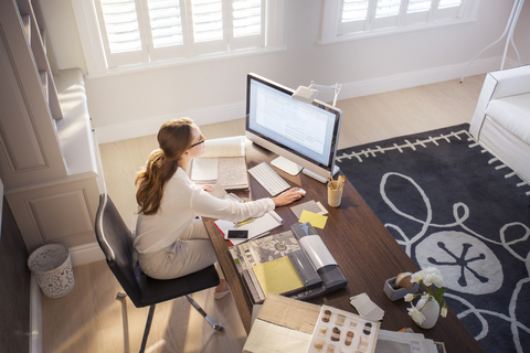 Innenarchitektin bei der Arbeit am Computer im Heimbüro, lizenzfreies Stockfoto