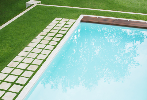 Pflastersteine in einer Reihe entlang des Schwimmbeckens im Hinterhof, lizenzfreies Stockfoto