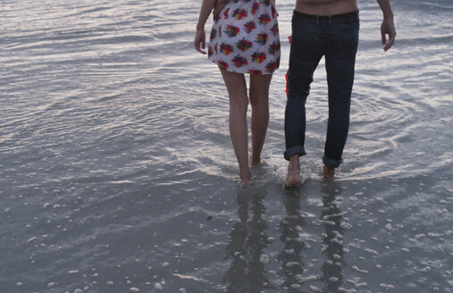 Junges Paar beim Spaziergang in der Meeresbrandung - HOXF00783