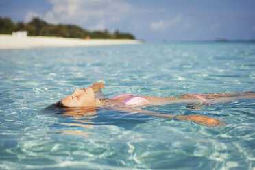 Gelassene Frau schwimmt im tropischen Ozean - HOXF00794