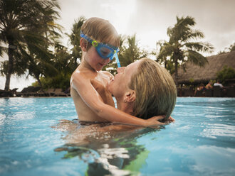 Mutter und Sohn umarmen sich im Schwimmbad - HOXF00796