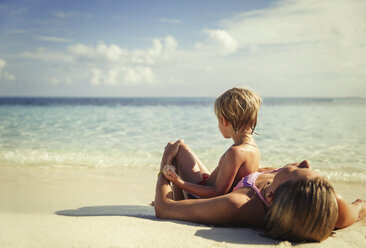 Mother and son laying and relaxing on tropical beach - HOXF00802