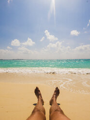Mann beim Sonnenbaden am sonnigen tropischen Strand - HOXF00807