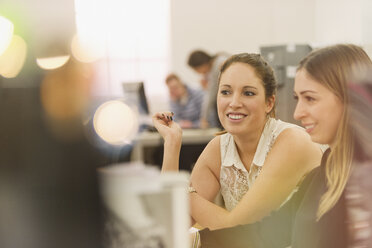 Smiling businesswomen working in office - HOXF00866