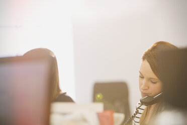 Geschäftsfrau telefoniert im Büro - HOXF00894