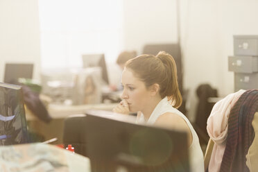 Konzentrierte Geschäftsfrau bei der Arbeit am Computer im Büro - HOXF00896