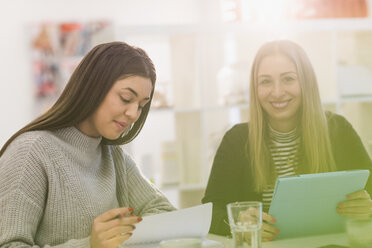 Porträt lächelnd Geschäftsfrauen mit digitalen Tablet Sitzung in sonnigen Büro - HOXF00909