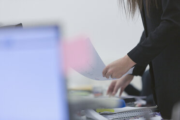 Geschäftsfrau hält Papierkram im Büro - HOXF00934