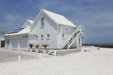 Weißes Strandhaus unter sonnigem blauem Himmel - HOXF00945