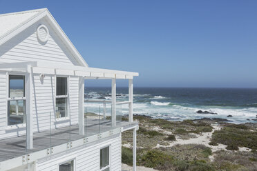 White beach house with ocean view under sunny blue sky - HOXF00948