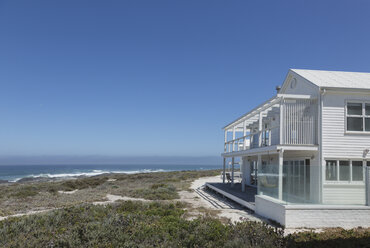 White beach house with ocean view under sunny blue sky - HOXF00950