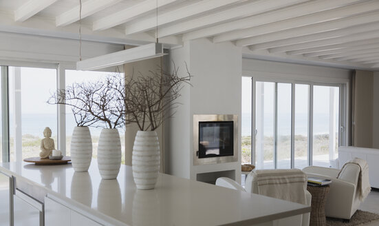 Moderne weiße Vasen mit Zweigen auf Kücheninsel in Strandhaus - HOXF00954