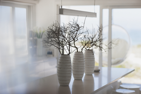Moderne weiße Vasen mit Zweigen auf der Kücheninsel, lizenzfreies Stockfoto